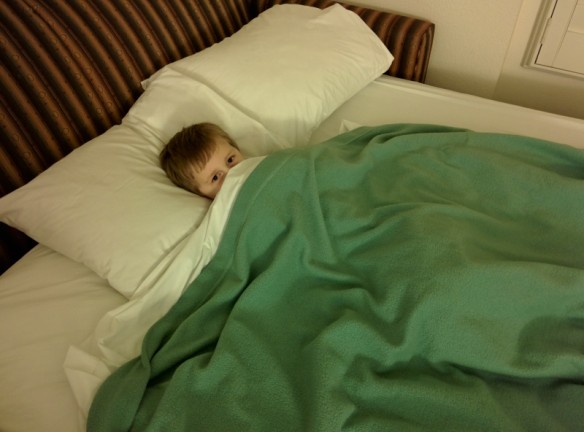 All snug in his bed, ready for a good night's rest at our hotel.